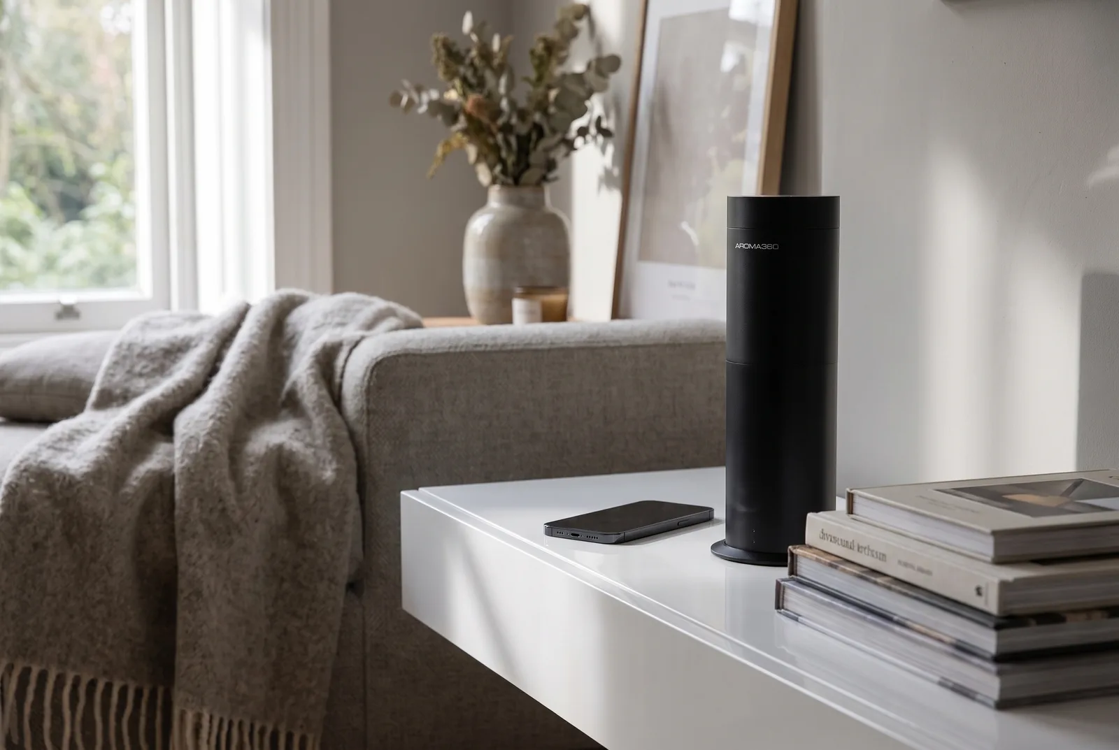 The Aroma 360 Mini360 SL diffuser on a hallway console beside a bowl of keys