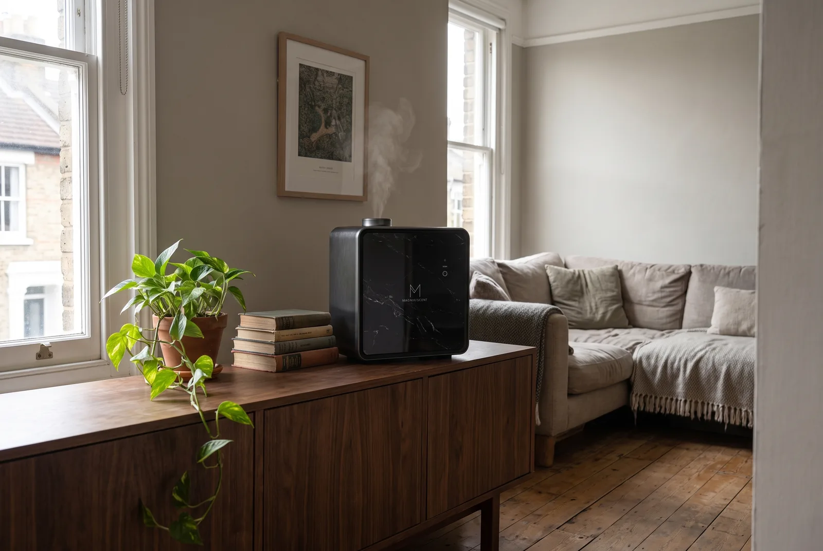 The Magnifiscent Monolith diffuser with its black marble front panel on a sideboard in a living room