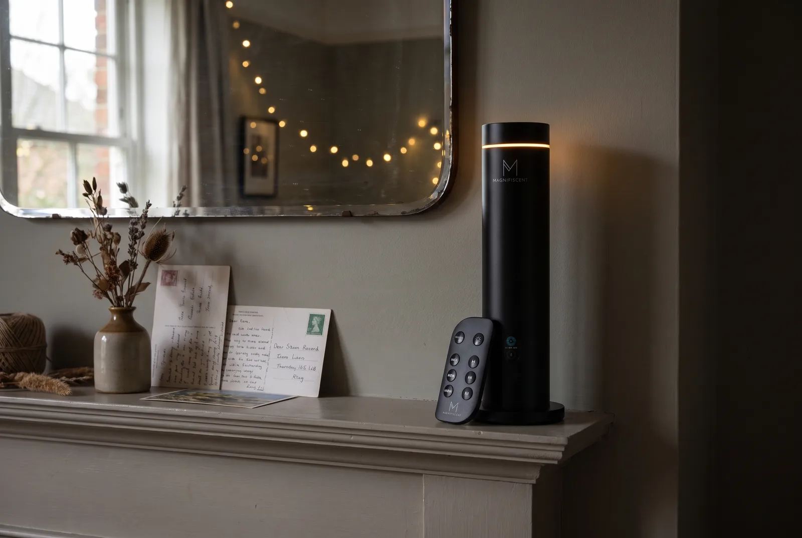 Magnifiscent NovaMist tower diffuser in black on a bedroom chest of drawers in soft evening light
