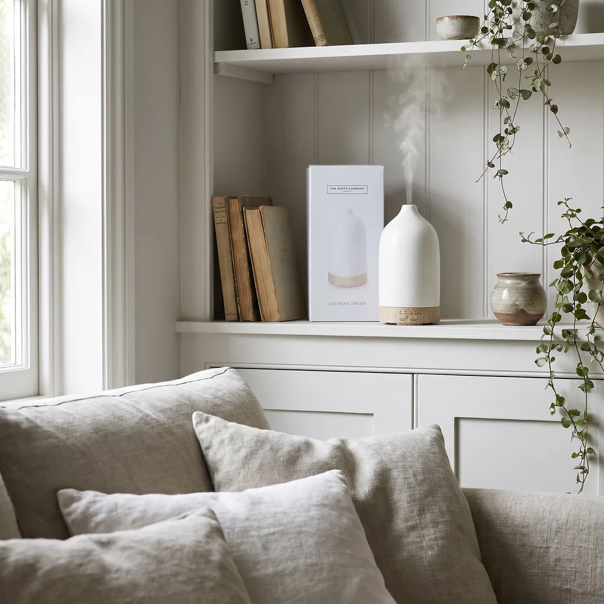The Electronic Diffuser on an alcove shelf in a white living room